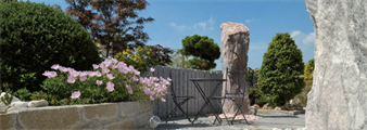 eine Steinkonstruktion mit einem Zaun und Blumen davor